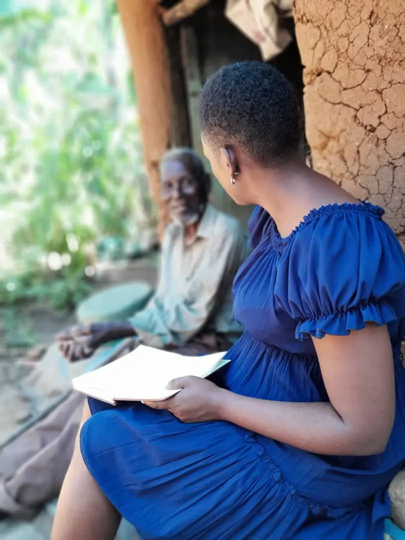 A MOD community health worker sitting with an elder